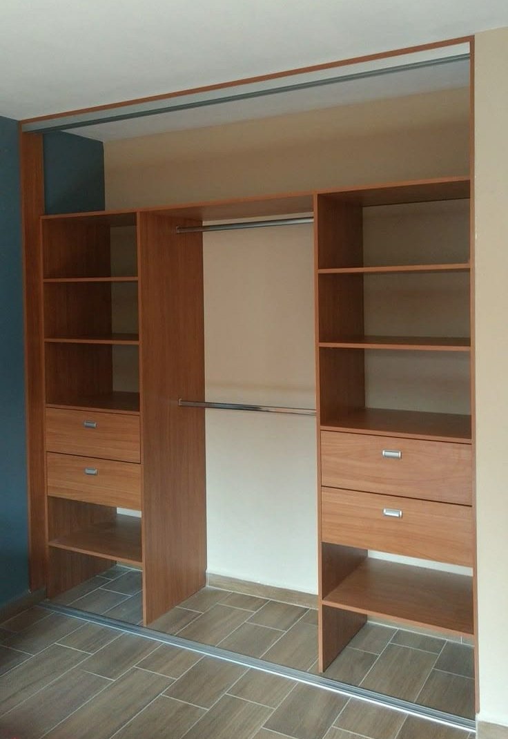 Interior de placard en madera oscura con cajoneras, estantes y barrales