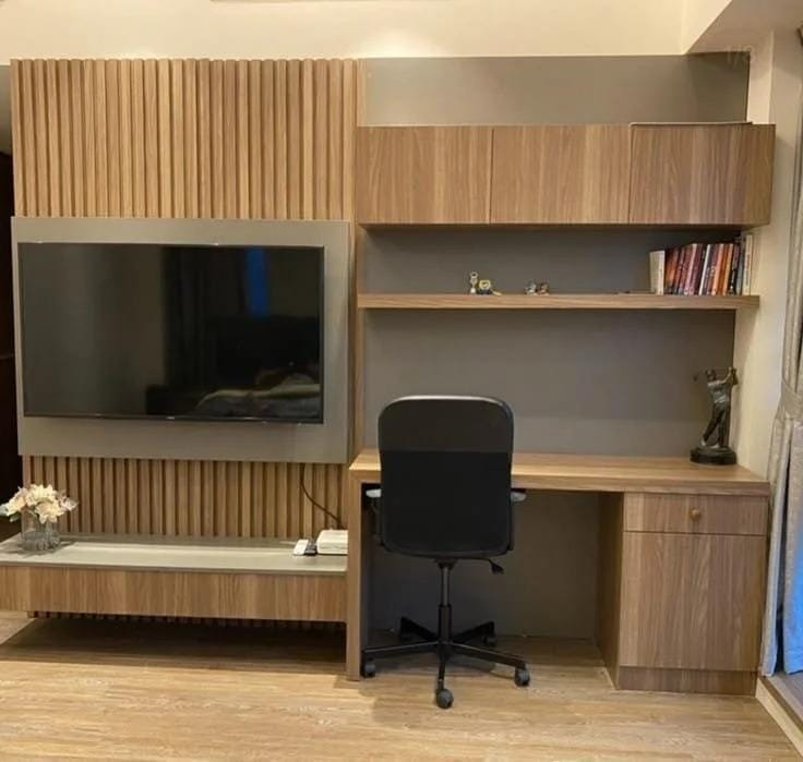 Escritorio empotrado con paneles de madera y estantes iluminados